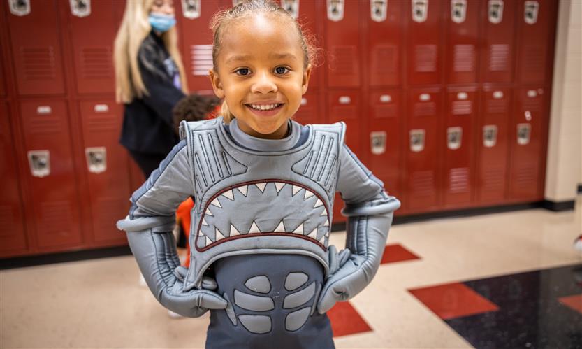 Children in costume trick or treat around school
